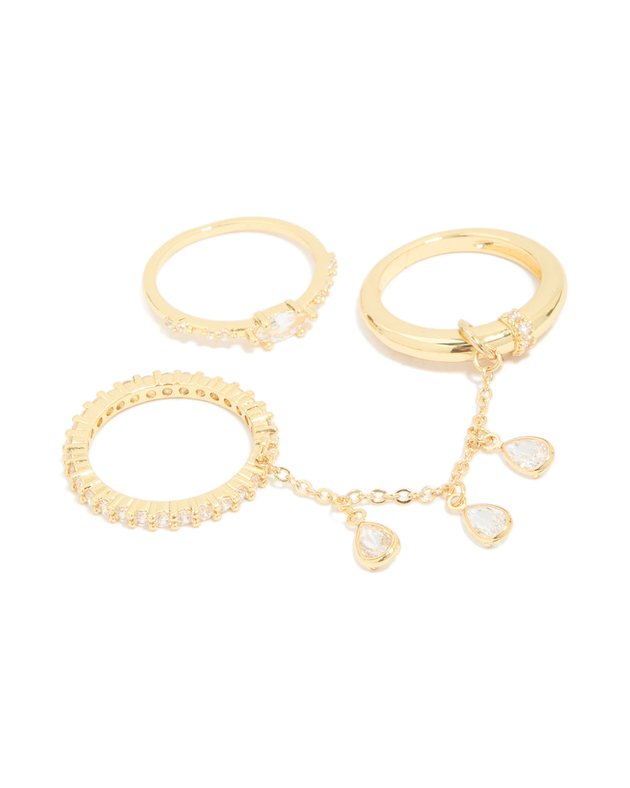 three gold rings: a crystal band, a ring with an oval stone and a ring with crystal droplet chains
