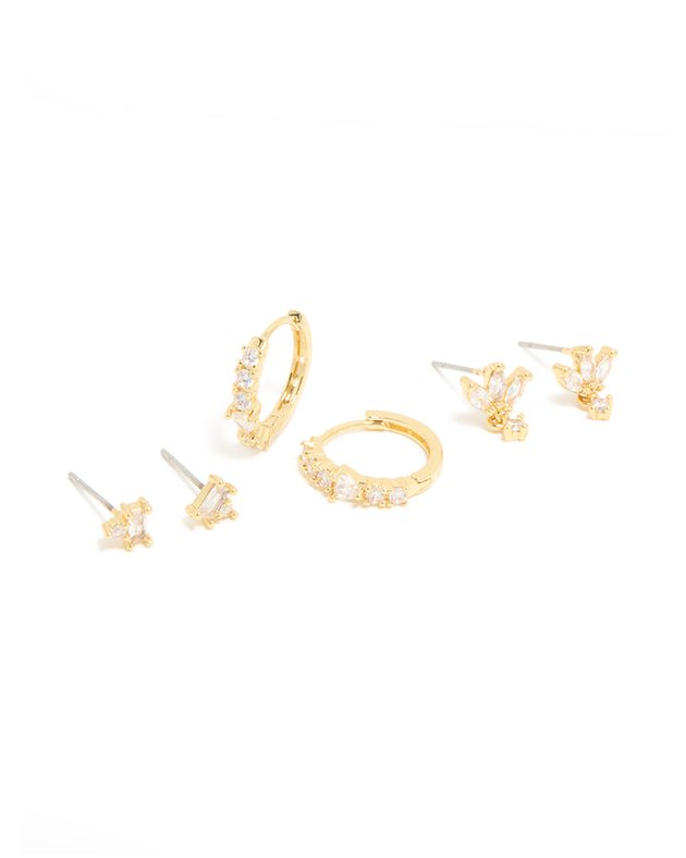 three pairs of gold earrings: sparkly huggie hoops, flower studs and crystal studs
