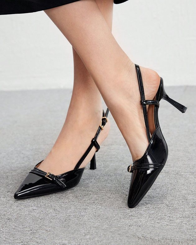 black patent pointed slingback stilettos worn on feet